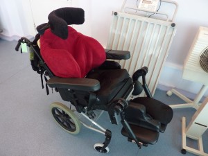A typical carer-propelled bespoke wheelchair including moulded foam seat and seat tilting mechanism