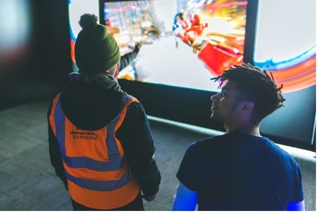 Nate watching a video on a screen with a child