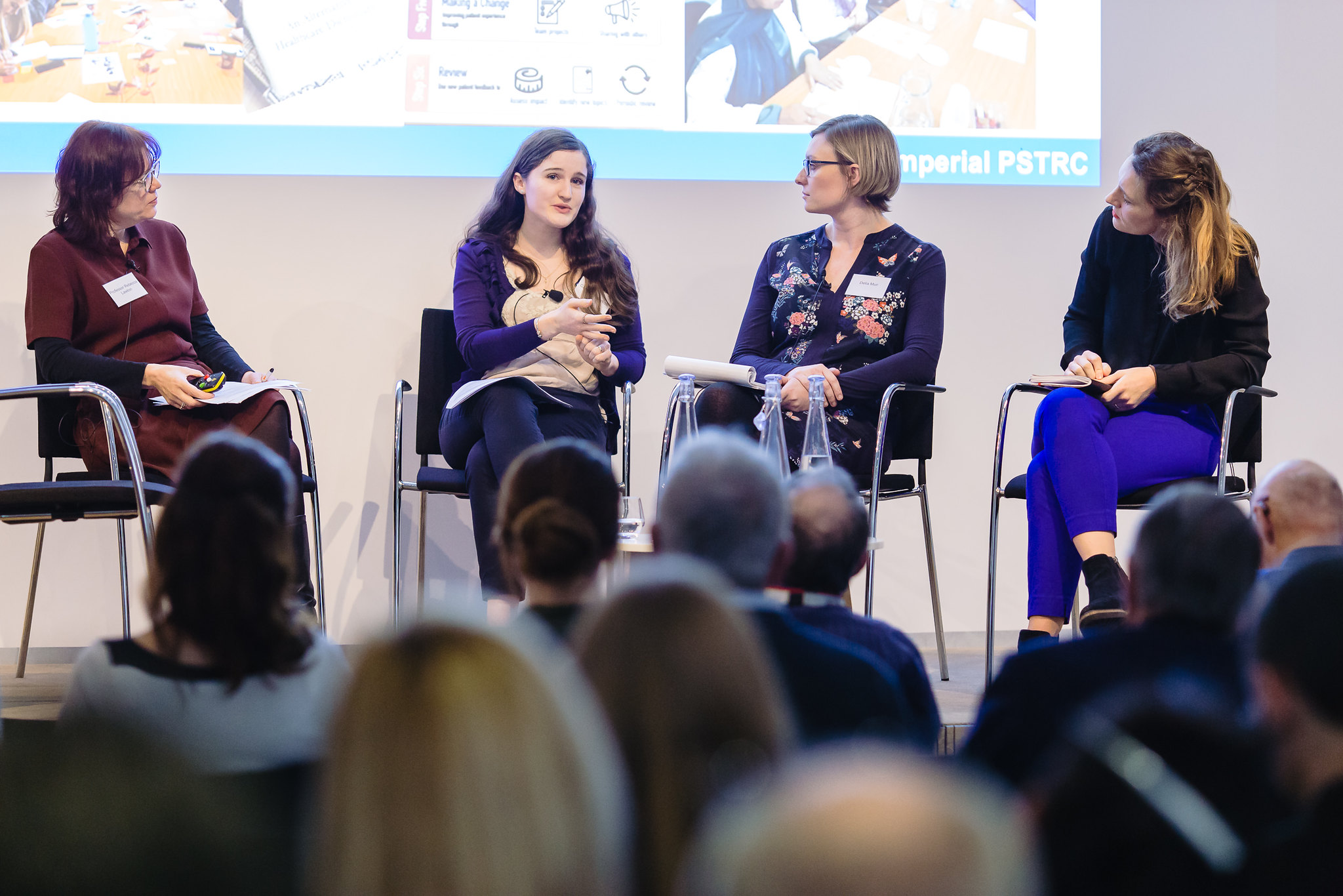 A photograph of an all-female panel discussing research involvement at a conference